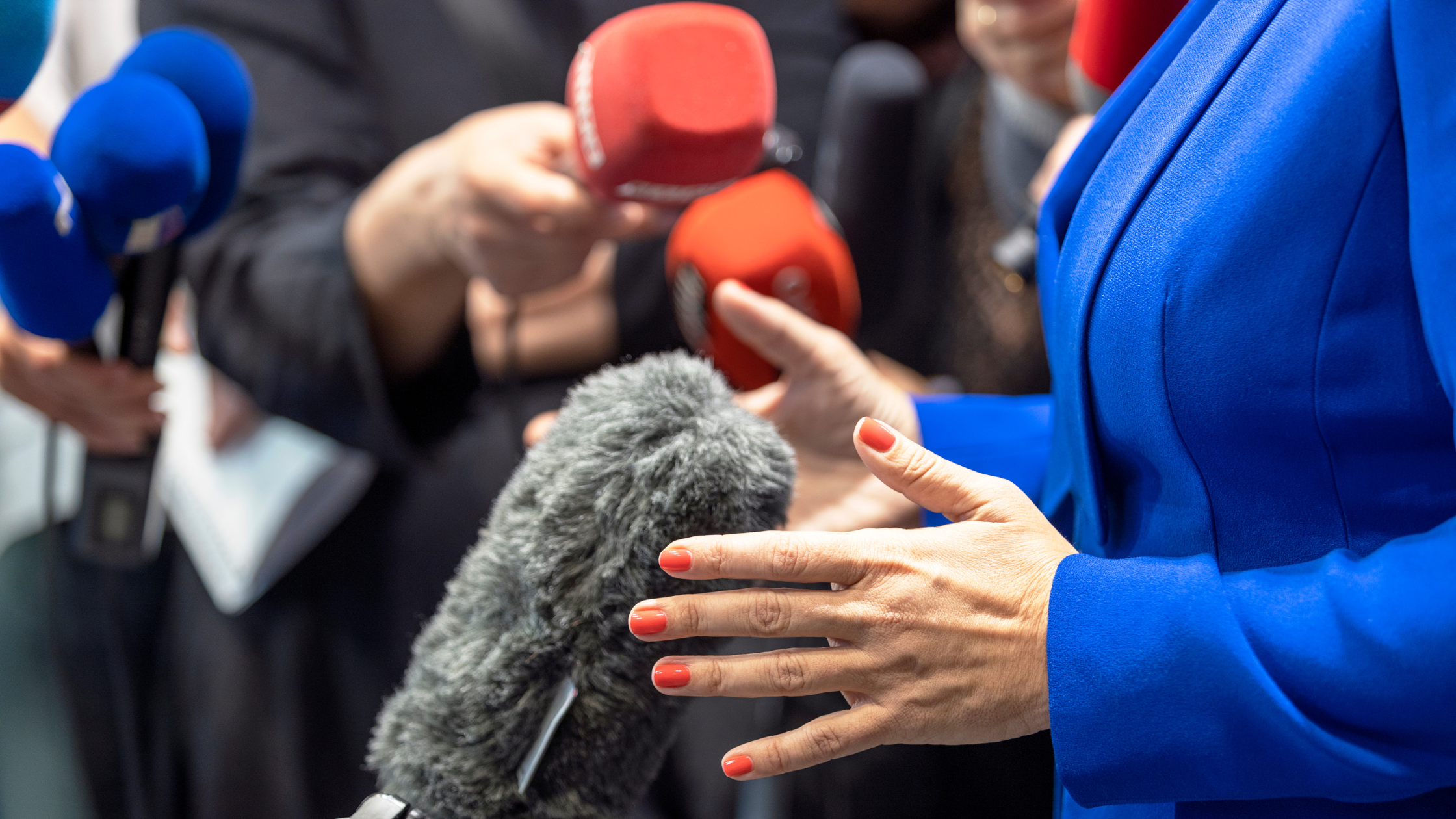closeup of hands of woman with microphones pointed at her