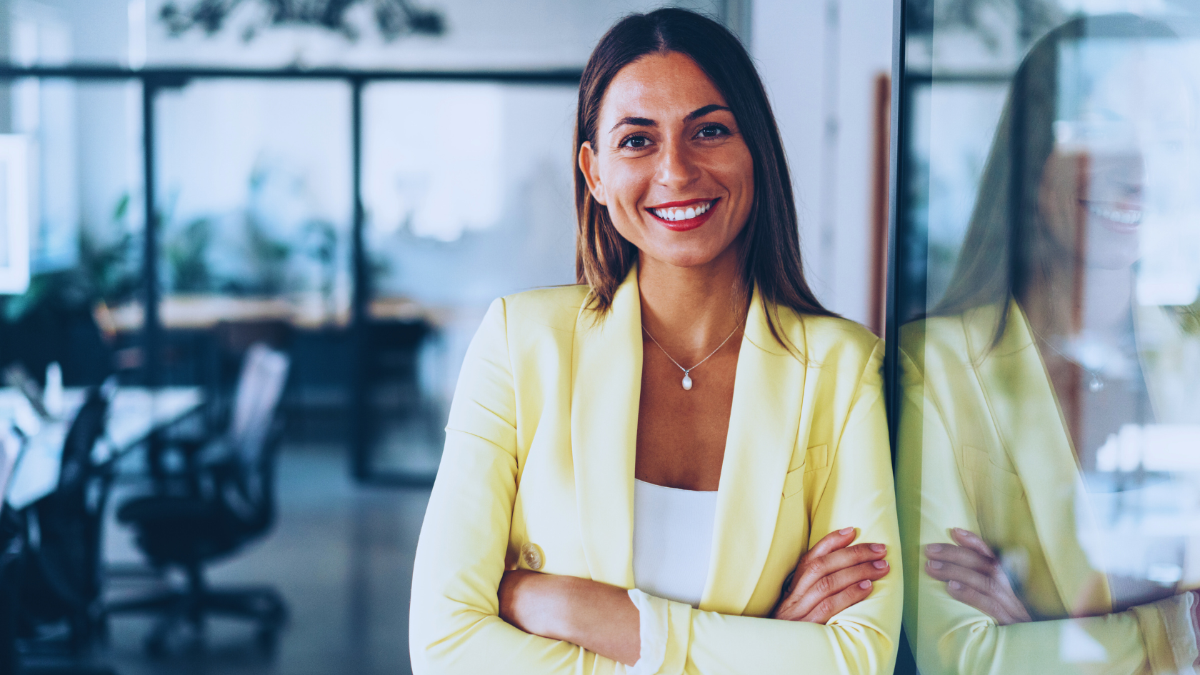Confident woman in yellow jacket with arms folded